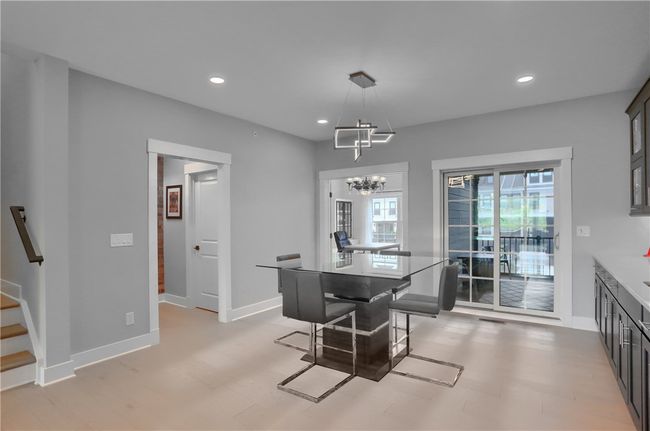 This open floor plan works for entertaining or cozy meals at home. The modern lighting adds to the contemporary style of the home. | Image 13