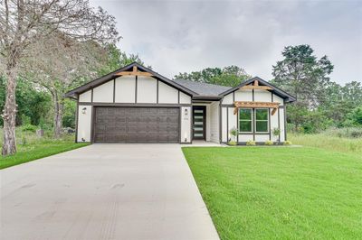 View of front facade with a front yard and a garage | Image 2