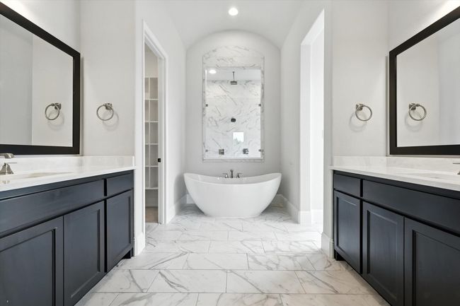 Full bathroom with marble finish floors, a freestanding bath, a marble finish shower, and two vanities | Image 24