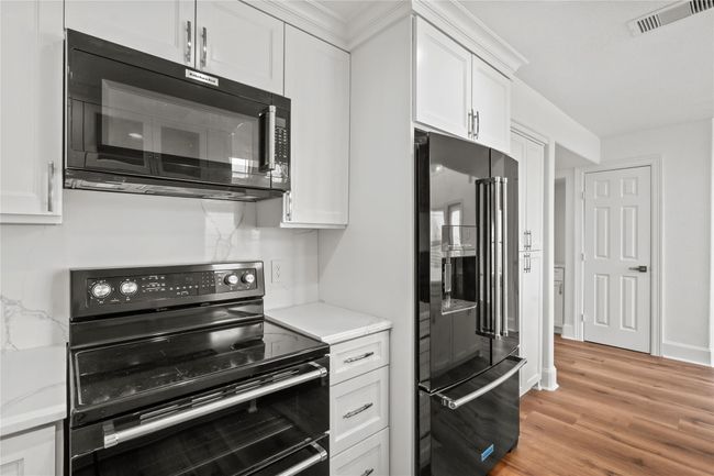New sleek, black appliances are a nice contrast to the countertops and cabinetry | Image 13