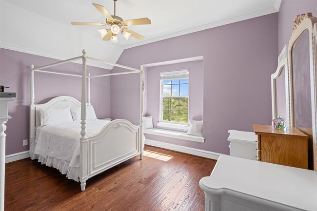 Bedroom with baseboards, ornamental molding, a ceiling fan, and wood finished floors | Image 27