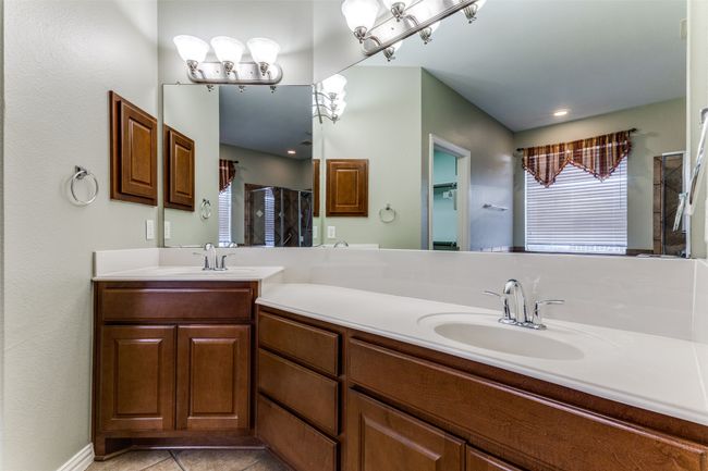 Bathroom featuring double vanity, a shower, and tile patterned flooring | Image 12