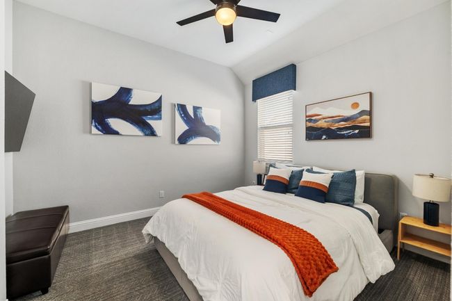 The third bedroom has a ceiling fan, large window and plush carpet. | Image 29