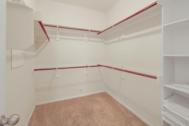 The walk-in closet is spacious and well-organized, offering plenty of room for your wardrobe and accessories, with built-in shelving and hanging space to keep everything neatly arranged | Image 25