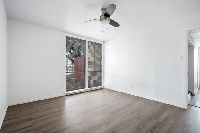Empty room featuring ceiling fan and dark wood-type flooring | Image 12