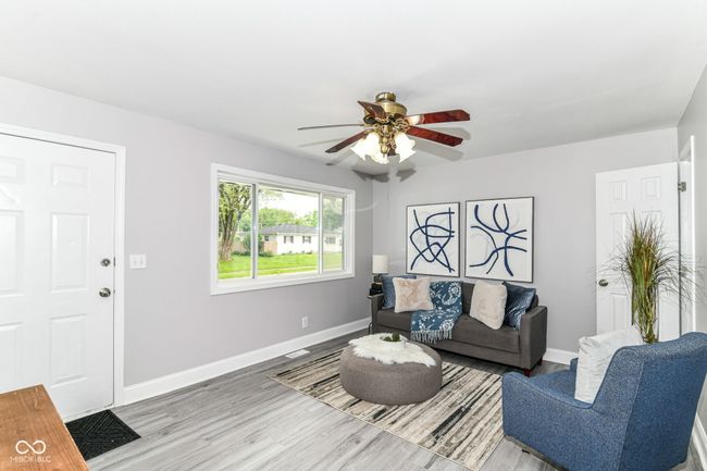living room with ceiling fan, baseboards, and wood finished floors | Image 6