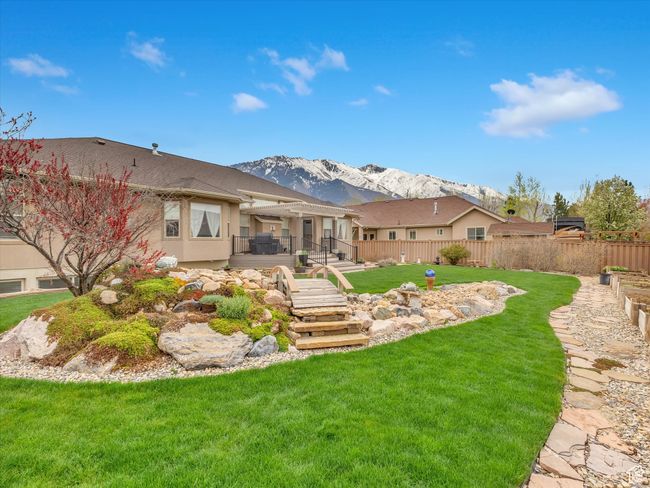 Back of property featuring fence, a deck with mountain view, a yard, and stucco siding | Image 44