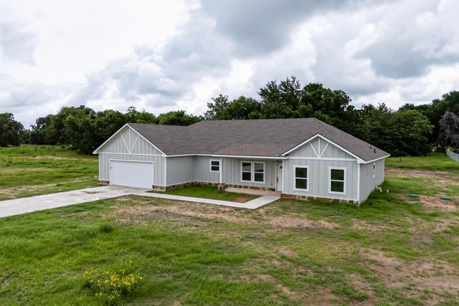 Single story home featuring roof with shingles, driveway, an attached garage, and a front yard | Image 5