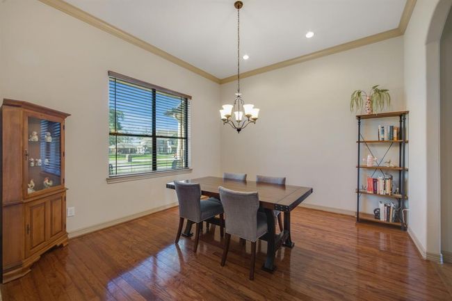 Spacious formal dining room sits off the kitchen and features wood flooring, canister lighting and crown molding. | Image 5