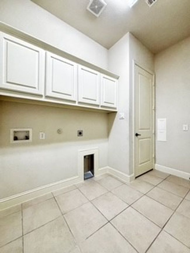 Washroom featuring cabinet space, electric dryer hookup, light tile patterned floors, hookup for a washing machine, and hookup for a gas dryer | Image 19