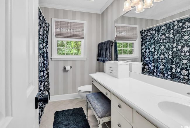 Bathroom with crown molding, wallpapered walls, vanity, a chandelier, and tile patterned floors | Image 20
