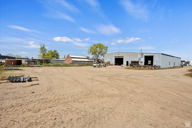 View of yard featuring an outbuilding, a pole building, and a garage | Image 12