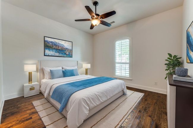Bedroom with visible vents, wood finished floors, baseboards, and ceiling fan | Image 13