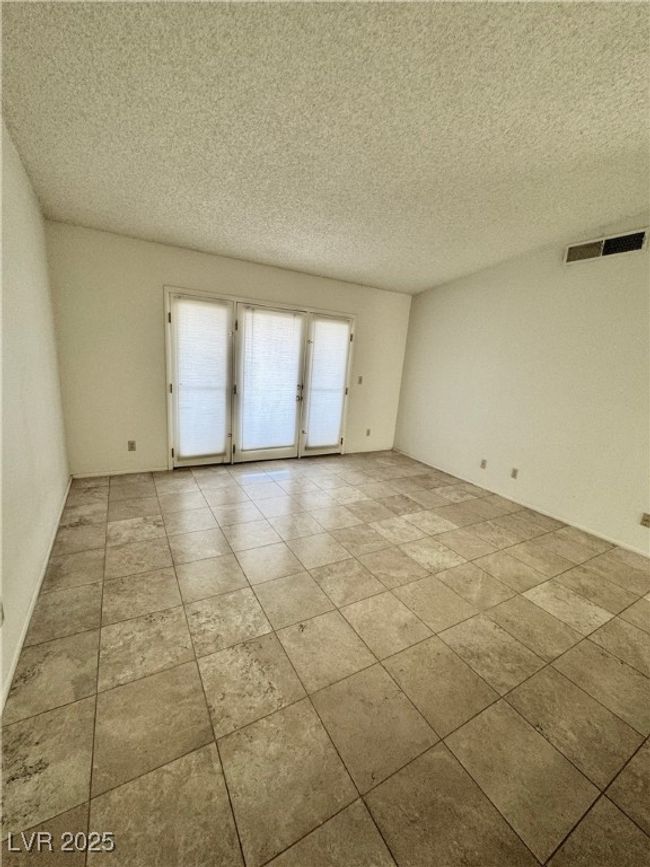 Empty room featuring a textured ceiling and french doors | Image 19