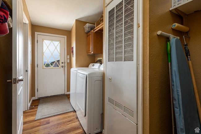 Laundry area with cabinets, washer and dryer, and light wood-type flooring | Image 22