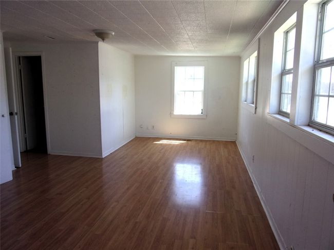 Unfurnished room featuring wood finished floors and baseboards | Image 11