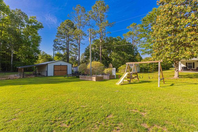 View of yard with a playground and an outdoor structure | Image 34