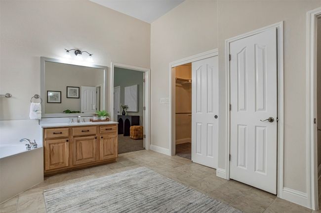 Bathroom featuring vanity, a garden tub, a walk in closet, and tile patterned floors | Image 20