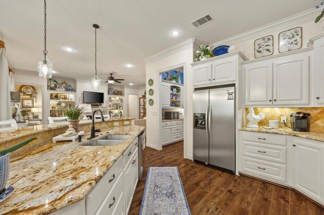 Kitchen featuring appliances with stainless steel finishes, ceiling fan, tasteful backsplash, white cabinetry, and sink | Image 20