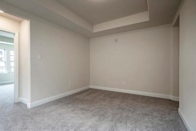 Unfurnished room with carpet, baseboards, and a raised ceiling | Image 13