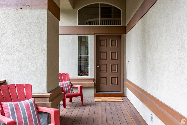Clubhouse: View of front facade with a gate, stone siding, concrete driveway, fence, and stucco siding | Image 35