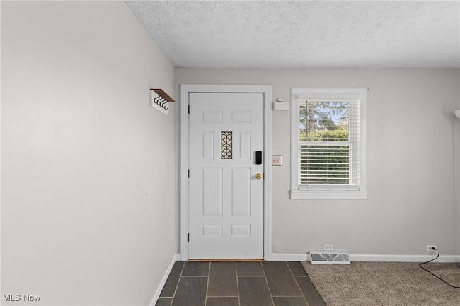 Foyer entrance featuring baseboards, visible vents, and a textured ceiling | Image 5