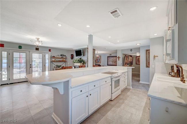 Kitchen featuring white electric range oven, a sink, white cabinets, recessed lighting, and baseboards | Image 56