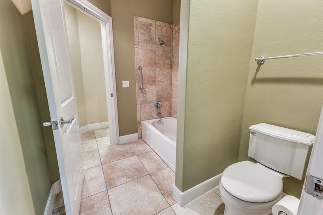 Bathroom with tile patterned floors, shower / tub combination, toilet, and baseboards | Image 21