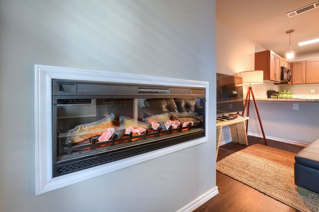 Interior details with visible vents, baseboards, black microwave, and wood finished floors | Image 9