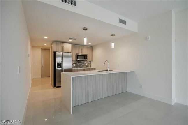 Kitchen with a peninsula, stainless steel appliances, visible vents, and baseboards | Image 18