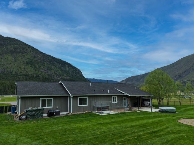 Rear view of property with a covered hot tub, a mountain view, and a patio | Image 46