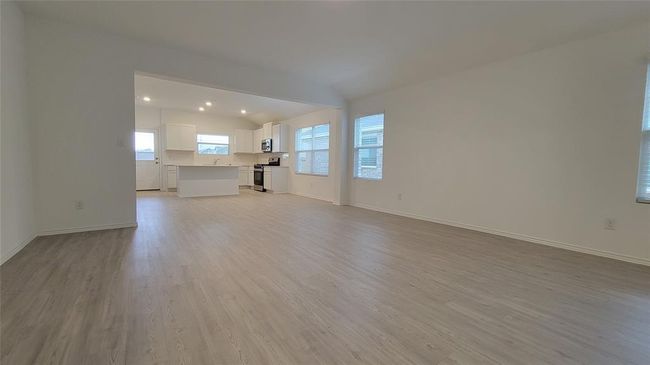 Unfurnished living room featuring light wood-type flooring, vaulted ceiling, and recessed lighting | Image 16