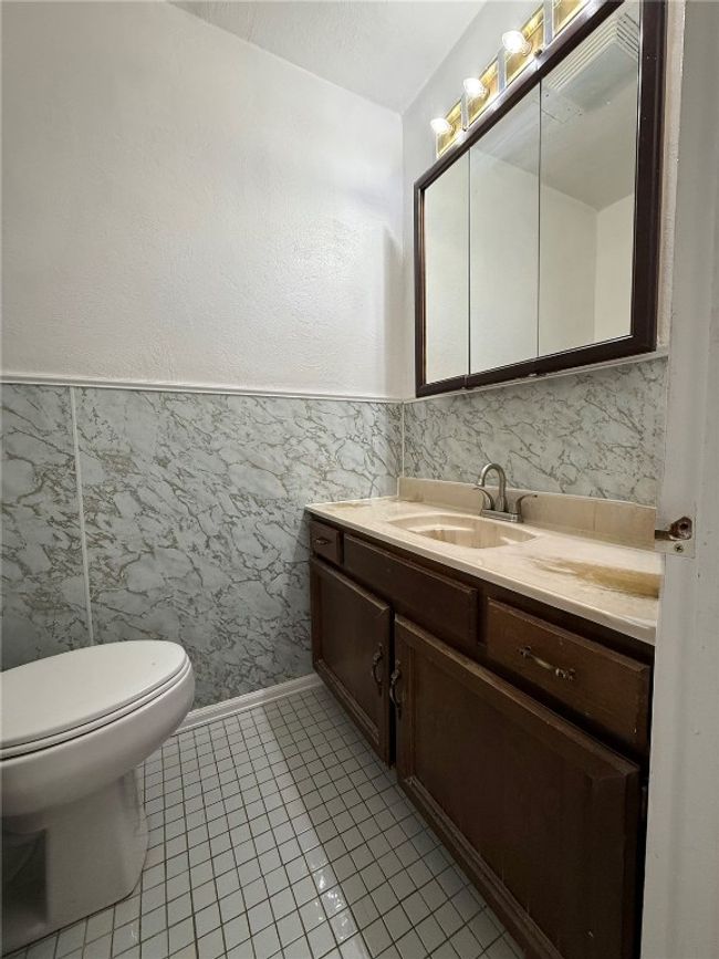 Half bathroom featuring vanity, toilet, tile patterned floors, and baseboards | Image 13