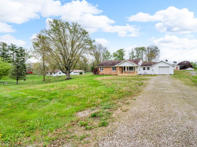 ranch-style house featuring covered porch, a garage, a front lawn, and driveway | Image 4