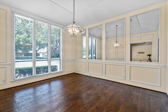 Unfurnished dining area featuring a chandelier, dark wood-type flooring, vaulted ceiling, and a wealth of natural light | Image 16