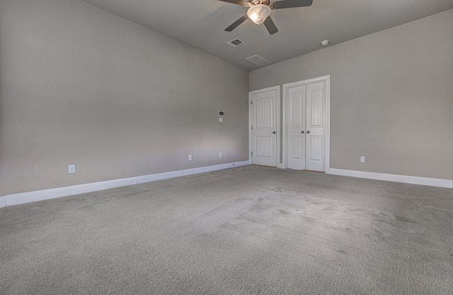 Unfurnished bedroom featuring carpet flooring, ceiling fan, a closet, and vaulted ceiling | Image 15