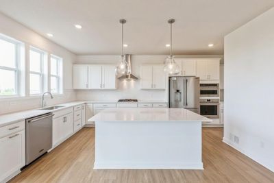 (Photo of a decorated model, actual finishes will vary) The spacious kitchen naturally serves as the heart of this home, complete with a generous center island, brand-new appliances and a walk-in pantry. | Image 1