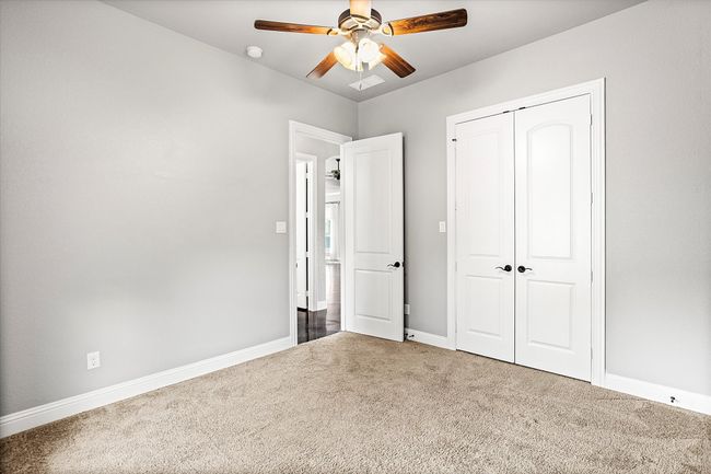 Unfurnished bedroom featuring carpet, a closet, baseboards, and ceiling fan | Image 26