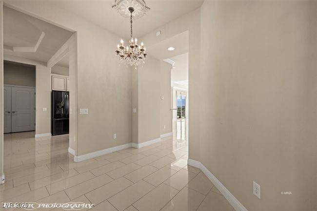 Unfurnished dining area with recessed lighting, light tile patterned floors, a notable chandelier, and baseboards | Image 6