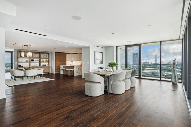 The dining room is surrounded by floor to ceiling windows and has access to the balcony, allowing for prime views to the north and west. | Image 10