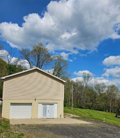 View of outdoor structure featuring a garage and a lawn | Image 2