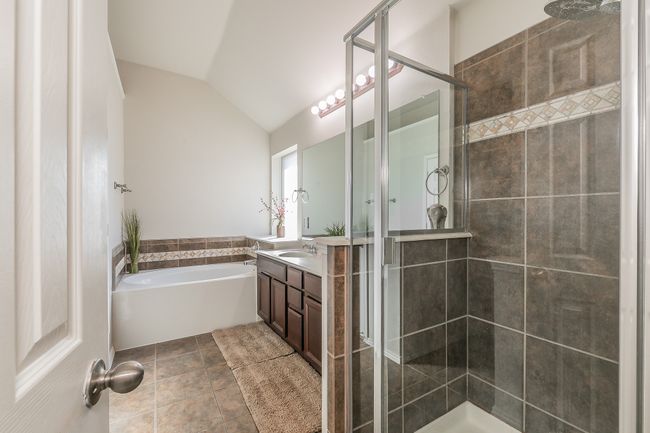 Bathroom with vanity, vaulted ceiling, a shower stall, tile patterned floors, and a bath | Image 23