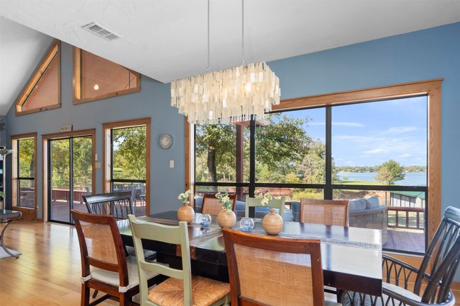 Dining area featuring a water view, a wealth of natural light, an inviting chandelier, and hardwood / wood-style flooring | Image 17