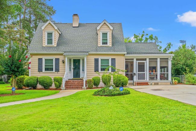 New england style home featuring a sunroom, a chimney, a front lawn, and roof with shingles | Image 28
