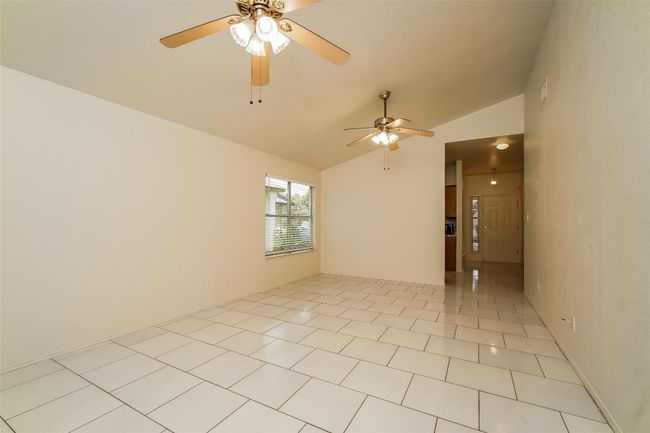Spare room featuring lofted ceiling, a ceiling fan, and light tile patterned floors | Image 8