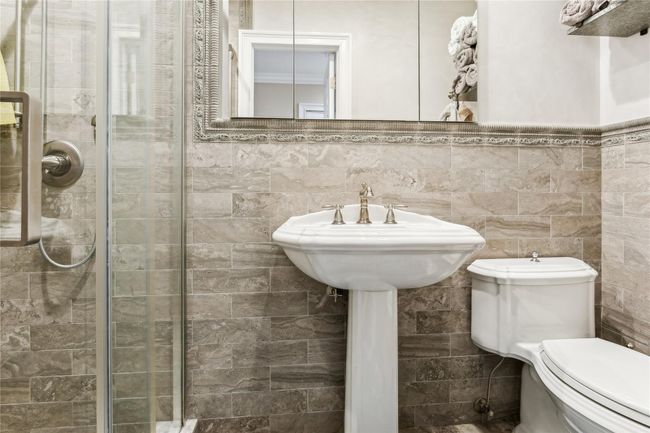 Bathroom featuring walk in shower, tile walls, and toilet | Image 14