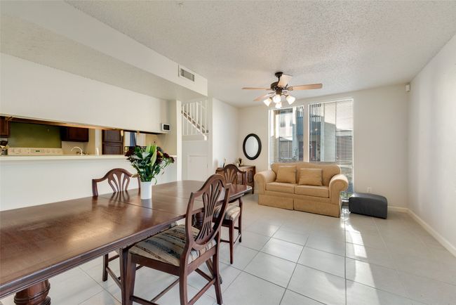 Dining area featuring ceiling fan, light tile patterned floors, and a textured ceiling | Image 9