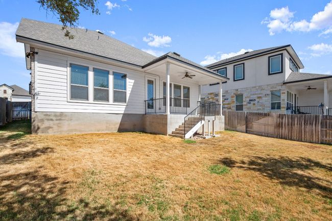 Rear view of property featuring a yard, a ceiling fan, a fenced backyard, and stairs | Image 28