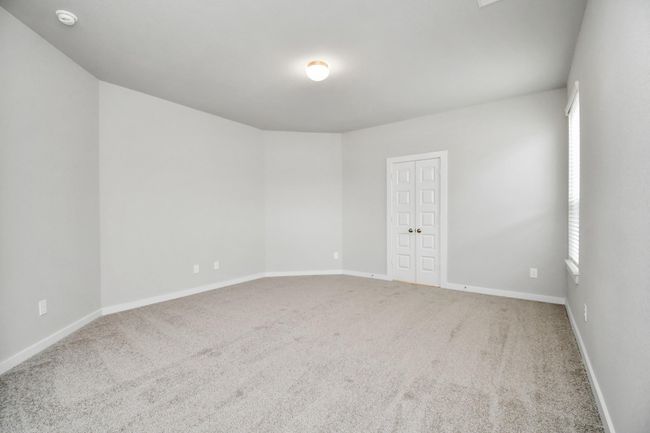Retreat to the luxurious primary suite, your perfect escape for unwinding after a long day. Located on the first floor, this spacious room features plush carpeting, calming paint tones, high ceilings, and large windows with privacy blinds. | Image 23