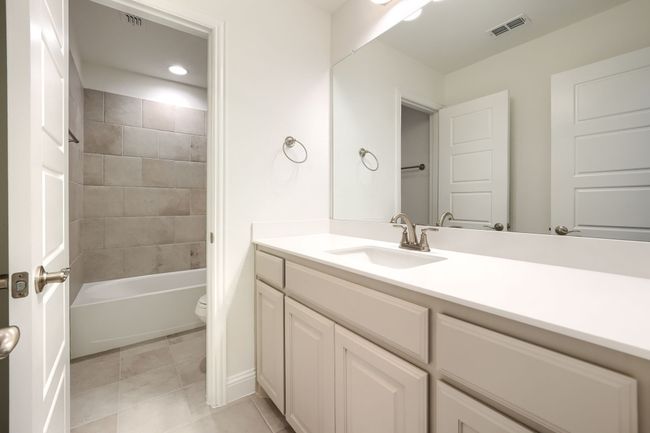 Full bathroom with tile patterned floors, vanity, washtub / shower combination, toilet, and visible vents | Image 28